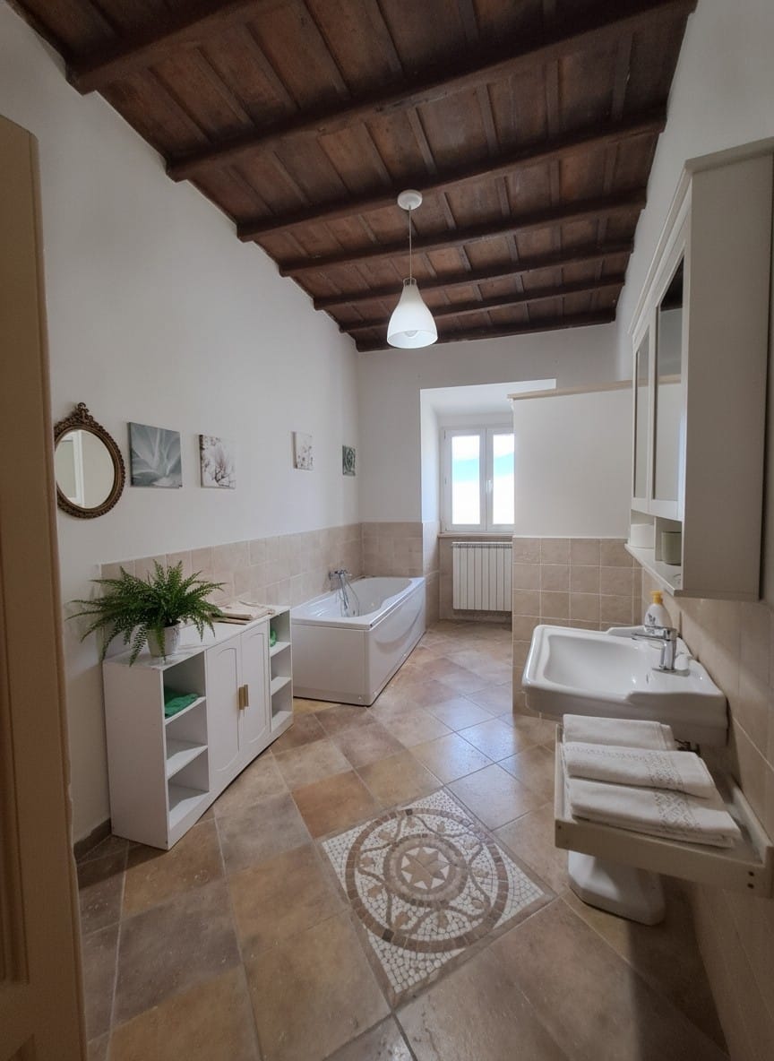 Bagno con vasca e travi a vista
